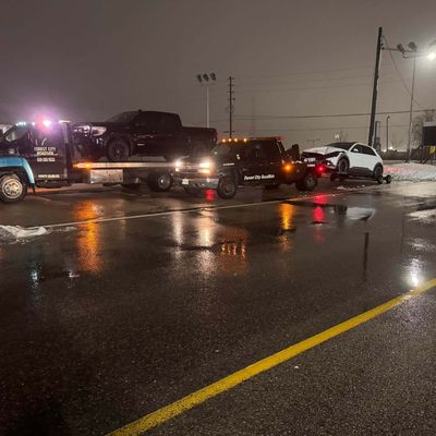 Flatbed and wrecker at night