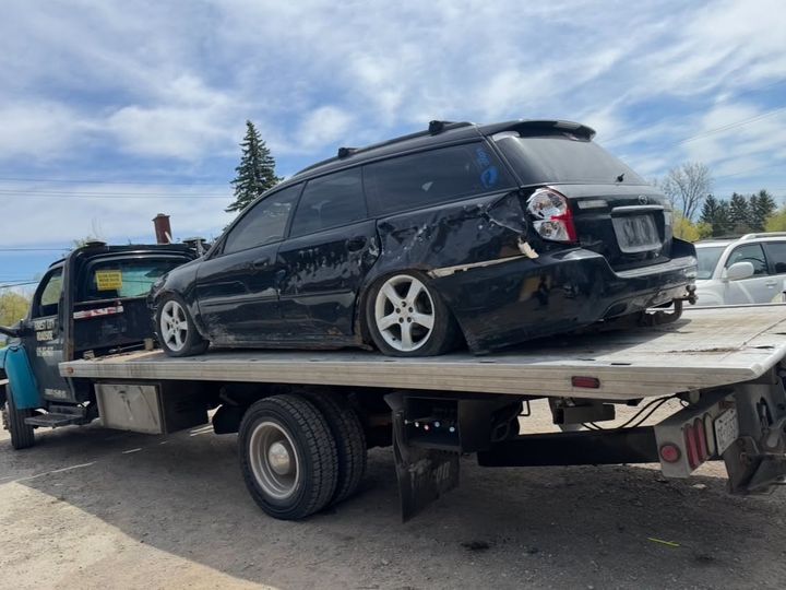Damaged vehicle being towed on a flatbed near Strathroy Ontario