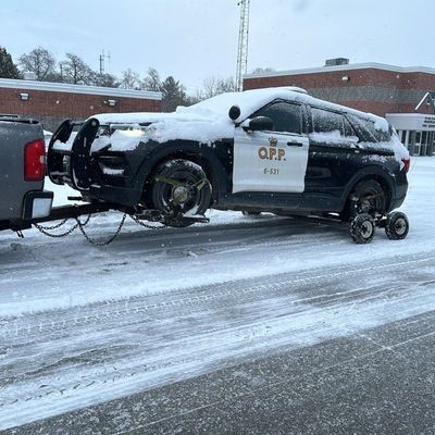 Wheel-lift tow truck towing an SUV in the snow